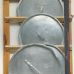 Verschiedene Topfdeckel an einem Wandregal